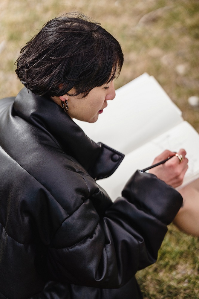 Woman drawing in notebook side angle - Continuing Education at Seattle Central College 