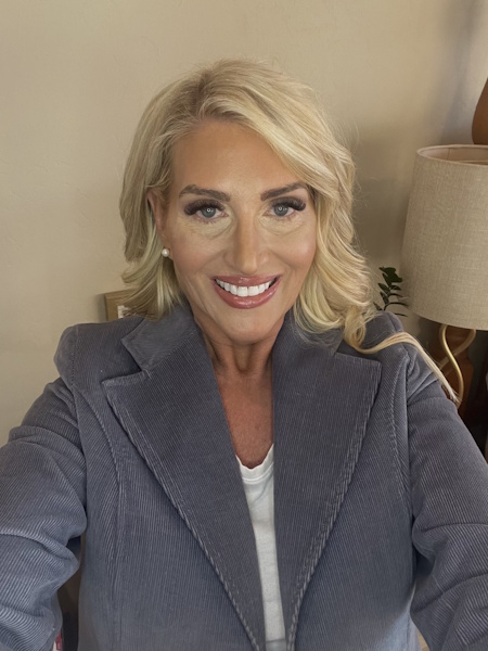 Beckie Larsen headshot of fair skinned blond woman smiling in office setting. 