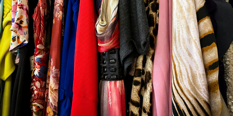 Colorful clothing hangs on rack. 